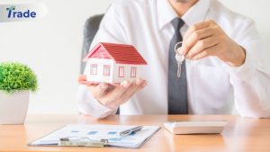 Photo of a mortgage broker holding keys and a model of a house.