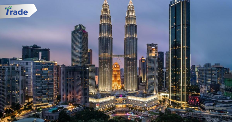 The Petronas Towers illuminated at night above a park in Kuala Lumpur, Malaysia